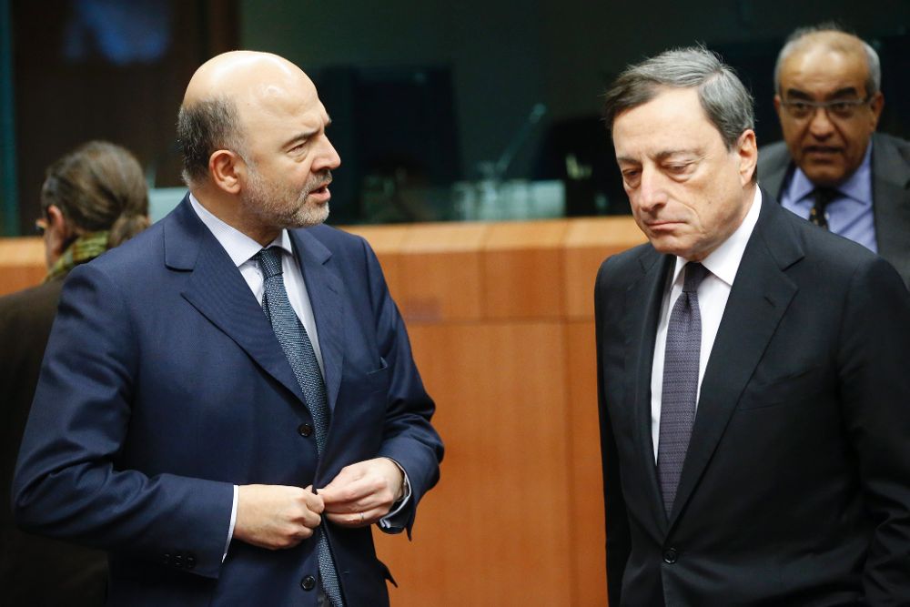 El presidente del Banco Central Europeo (BCE), Mario Draghi (d), conversa con el comisario europeo de Asuntos Económicos, Pierre Moscovici.