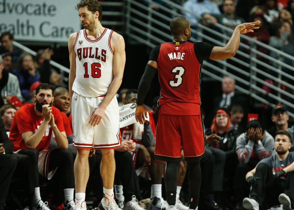Pau Gasol (i) de Bulls reacciona mientras Dwyane Wade de Heat celebra una cesta durante el partido en el United Center de Chicago, Illinois (EE.UU.).