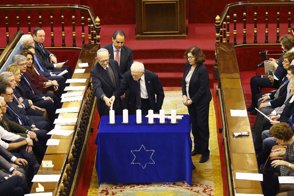 Presos de campos de concentración encienden unas velas durante el acto que se celebra hoy en el Senado.