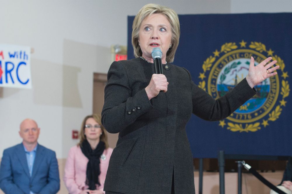 La aspirante a la candidatura demócrata Hillary Clinton (c), pronuncia un discurso junto a la excongresista Gabby Giffords (detrás-d), y su esposo Mark Kelly (detrás-i), durante un acto electoral celebrado en Derry, Nuevo Hampshire.