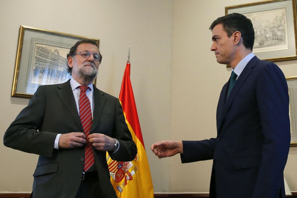 Momento en el que Rajoy se abrocha la chaqueta y deja a Pedro Sánchez con la mano tendida.