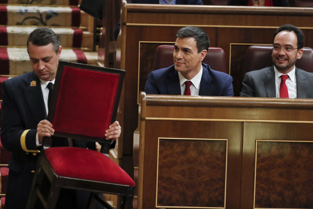 Un ujier pasa con una silla ante el secretario general del PSOE, Pedro Sánchez (c), y el portavoz socialista, Antonio Hernando (d), durante la sesión de la tarde de la segunda jornada del debate de investidura.