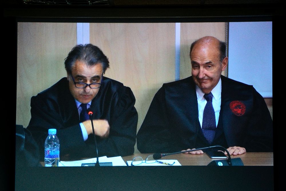 Los abogados de la Infanta Cristina, Pau Molins (i) y Miquel Roca Junyent a través del monitor de la sala de prensa.