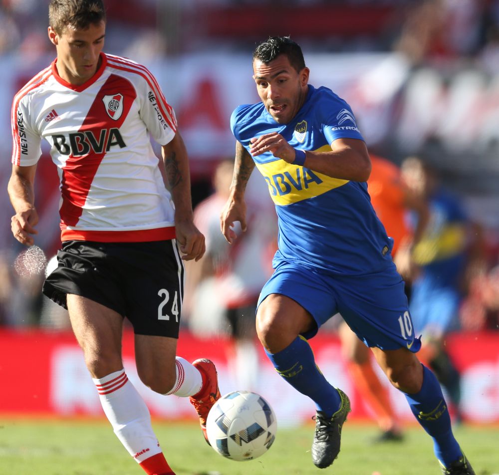 Carlos Tévez (d) de Boca Juniors disputa el balón con Emanuel Mammana (i) de River Plate.
