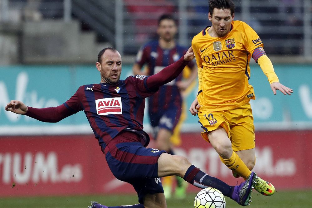 El delantero argentino del FC Barcelona Lionel Messi (d) y el defensa del Eibar Iván Ramis, durante el partido.