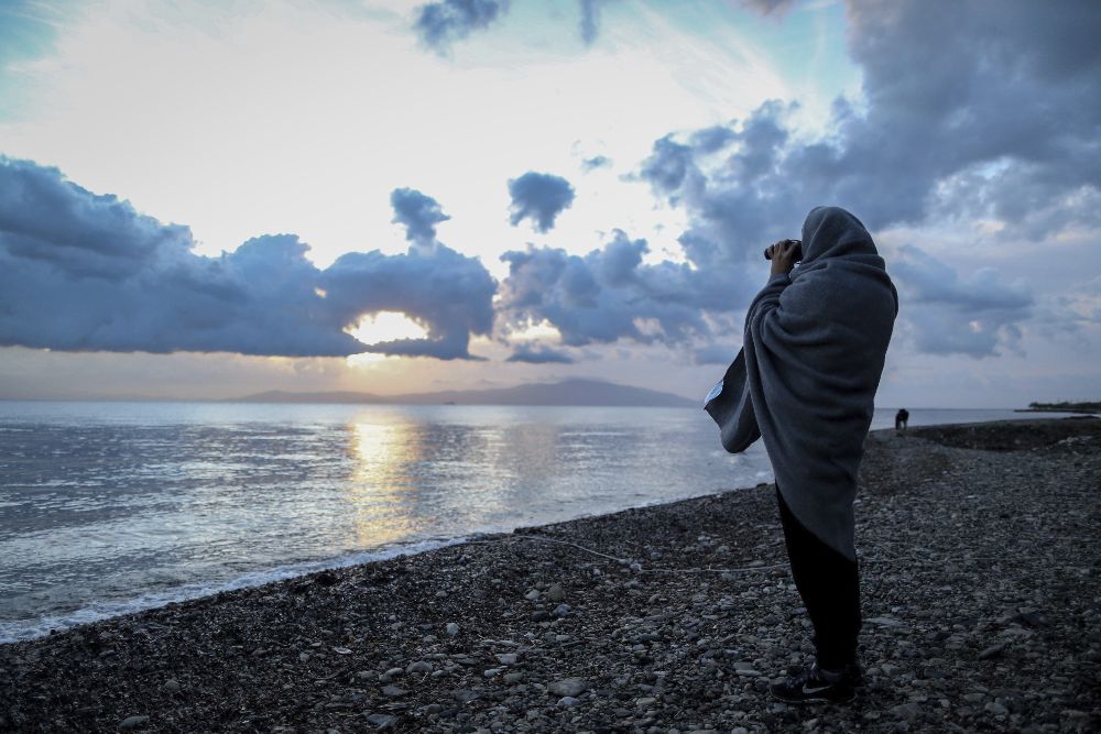 Un voluntario observa el horizonte con prismáticos desde una playa en la isla de Lesbos cerca del puerto de Mytilene (Grecia) hoy, 11 de marzo.