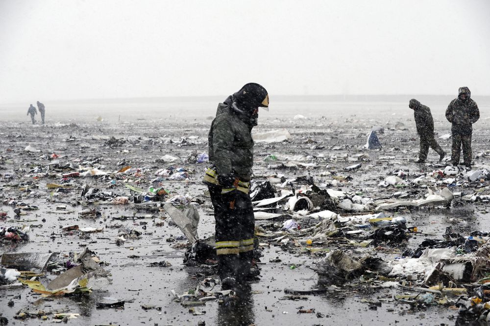 Un bombero busca las cajas negras entre los restos del avión de pasajeros de Flydubai.