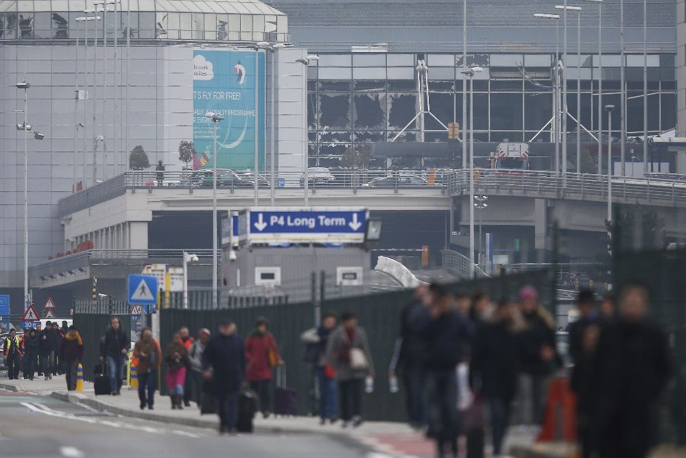 Pasajeros y trabajadores evacúan el dificcio de la terminal tras registrarse explosiones en el aeropuerto internacional de Zaventem, cerca de Bruselas (Bélgica) hoy, 22 de marzo de 2016.
