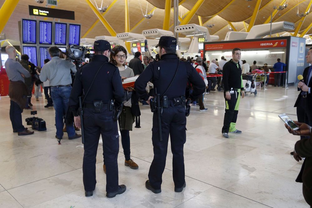 Agentes de la Policía Nacional y un gran número de periodistas permanecen en la T4 del aeropuerto Adolfo Suárez Madrid-Barajas.
