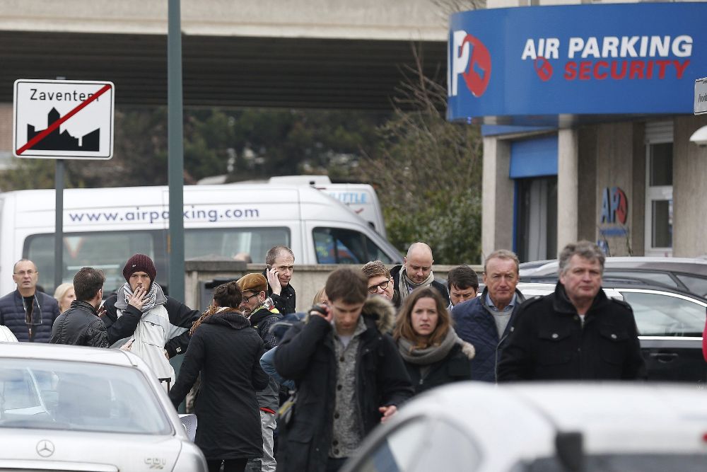 Varias personas abandonan la zona aeroportuaria tras registrarse las explosiones en el aeropuerto de Bruselas en Zaventem.