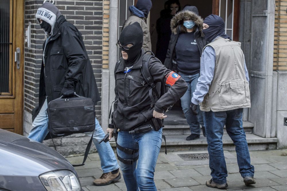 Varios policías belgas recogen pruebas de una vivienda del número 64 de la calle Busselenberg, en el distrito de Anderlecht-Bruselas, durante una redada efectuada hoy, miércoles.