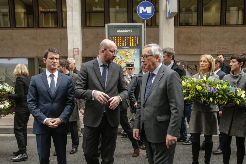 El primer ministro belga Charles Michel (c), el presidente de la Comisión Europea Jean-Claude Juncker (3d) y el primer ministro francés Manuel Valls (i) durante un homenaje a las víctimas de los atentados de ayer en la estación de metro de Maalbeek.