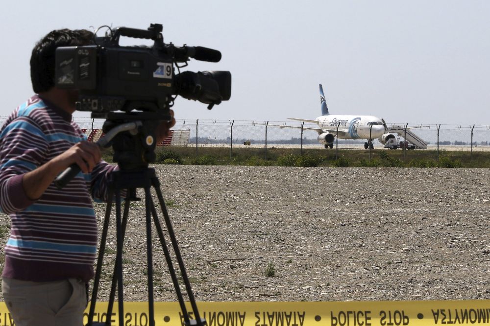 Un operador de cámara toma imágenes del avión de Egiptair secuestrado por un pasajero con un cinturón explosivo en el aeropuerto de Larnaca (Chipre). 