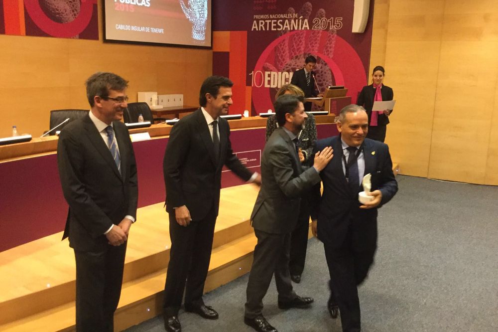 El consejero insular Efraín Medina recoge el premio mientras lo felicita Carlos Alonso. A la izquierda de este, el ministro de Industria en funciones, José Manuel Soria.