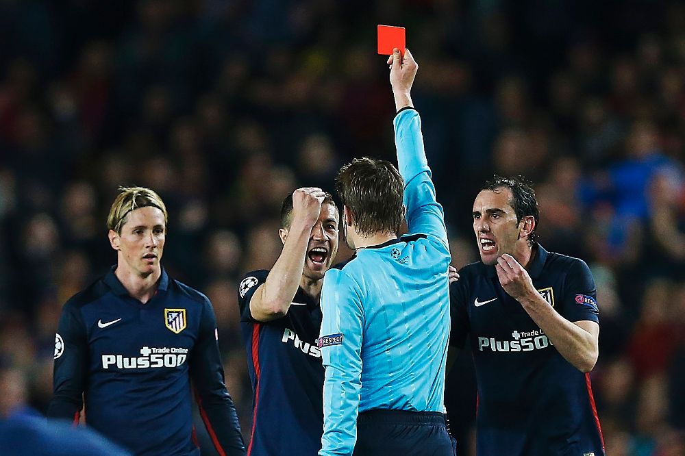 El árbitro alemán Felix Brych muestra tarjeta roja al delantero del Atlético de Madrid Fernando Torres (i).