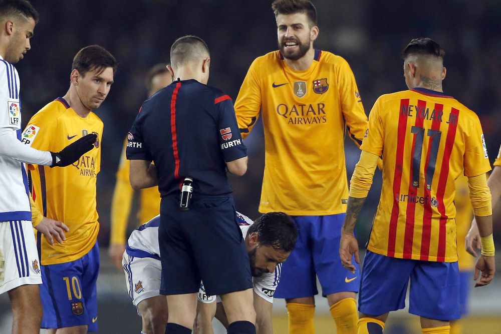 El defensa del FC Barcelona Piqué (2-d) discute una decisión del árbitro Iglesias Villanueva (3-i), durante el partido de Liga ante la Real Sociedad.