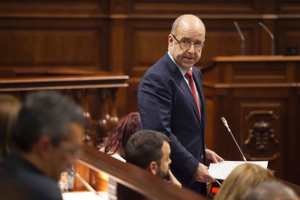 El consejero de Economía, Industria, Comercio y Conocimiento del Gobierno de Canarias, Pedro Ortega, responde a diversas cuestiones durante el Pleno del Parlamento.