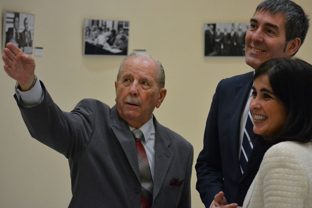 Trino Garriga explica alguna foto a la presidenta del Parlamento y al presidente del Gobierno canario.