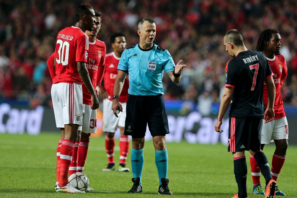 El árbitro Bjoern Kuipers (c) discute con jugadores del Benfica y del Bayern Munich.