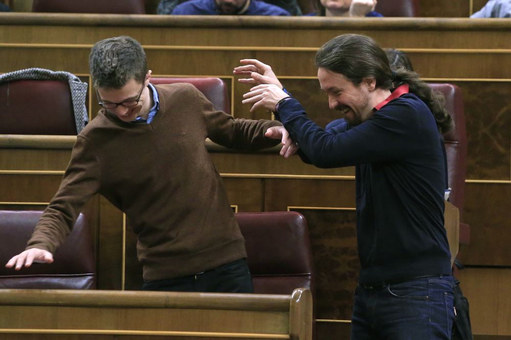 El líder de Podemos, Pablo Iglesias (d), y el portavoz del partido, Íñigo Errejón, bromean poco antes del pleno del Congreso de los Diputados de hoy.