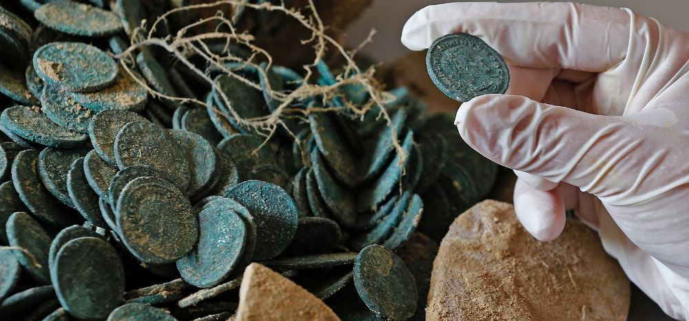 Una de las monedas encontradas en las diecinueve ánforas romanas descubiertas ayer en la localidad sevillana.