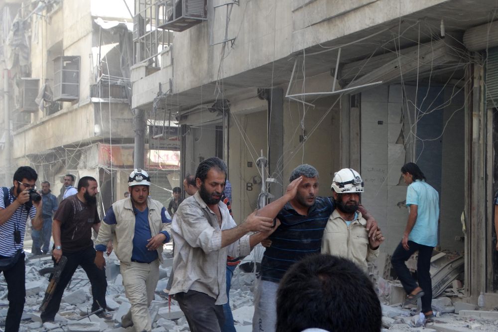 Varias personas huyen de los ataques aéreos del jueves sobre Alepo.