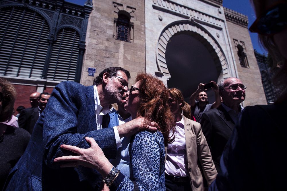 Mariano Rajoy saluda a una mujer a las afueras del Mercado de Atarazana, durante el recorrido por el centro de la ciudad de Málaga.
