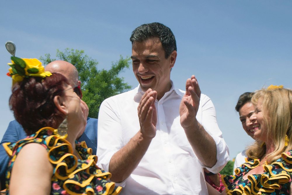 El secretario general del PSOE, Pedro Sánchez, toca las palmas a unas mujeres vestidas de flamenca,