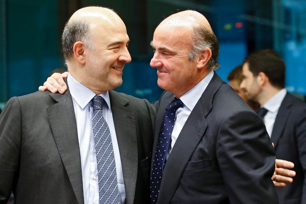 El comisario europeo de Asuntos Económicos, Pierre Moscovici, (i), conversa con Luis de Guindos durante la reunión del Eurogrupo celebrada en Bruselas hoy.
