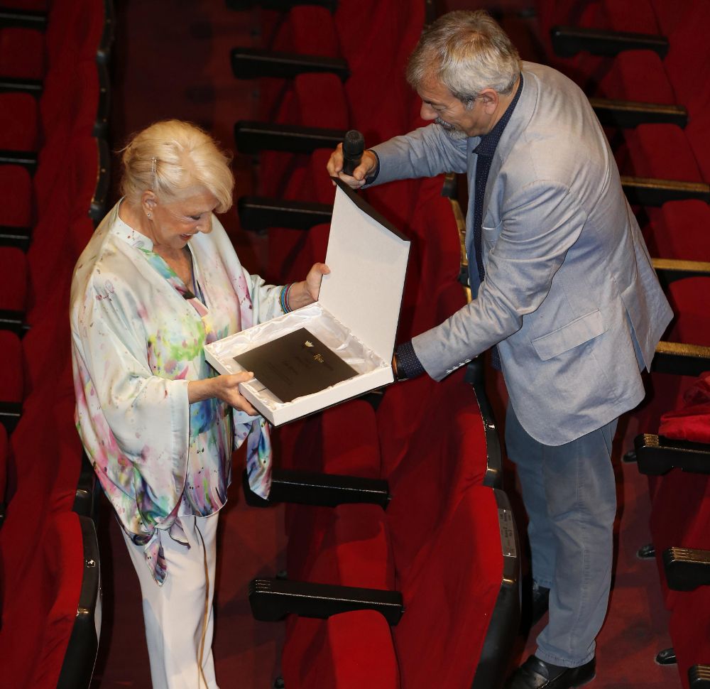 El actor Carlos Sobera, acompañado por la actriz Lola Herrera, a quien entrega una placa, durante la presentación de la compra del Teatro Reina Victoria por parte del actor y de los actos del centenario.