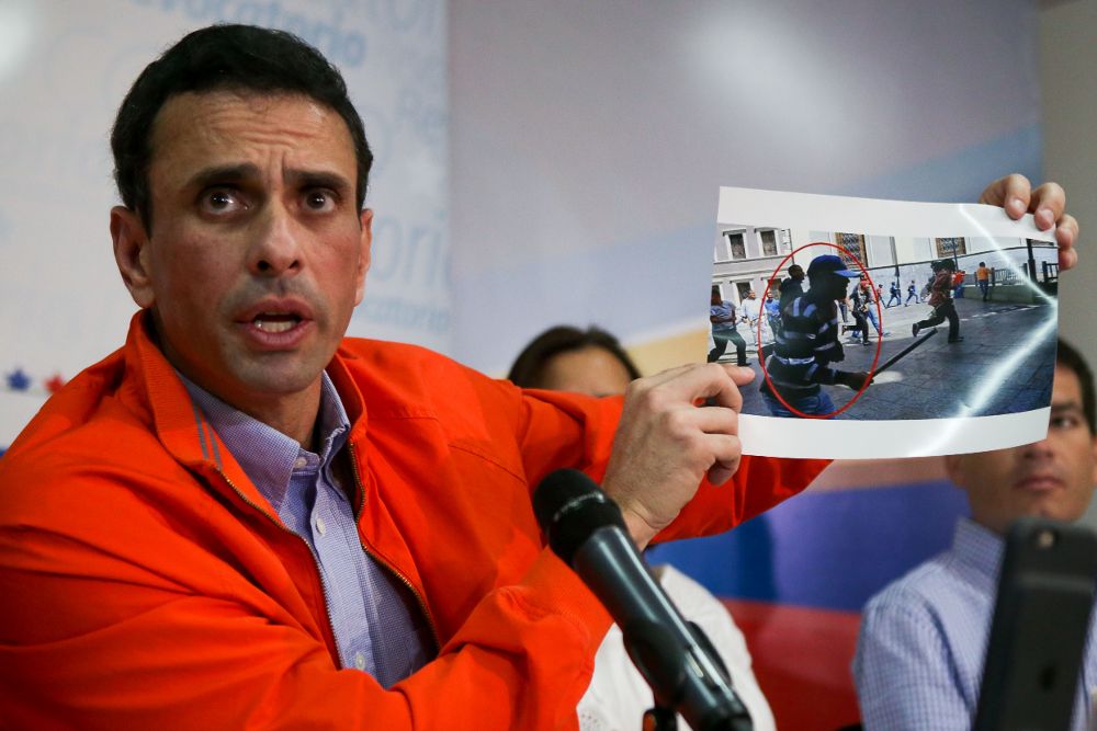 El excandidato a la Presidencia de Venezuela Henrique Capriles muestra imágenes de los supuestos autores de las agresiones que sufrieron diputados opositores.