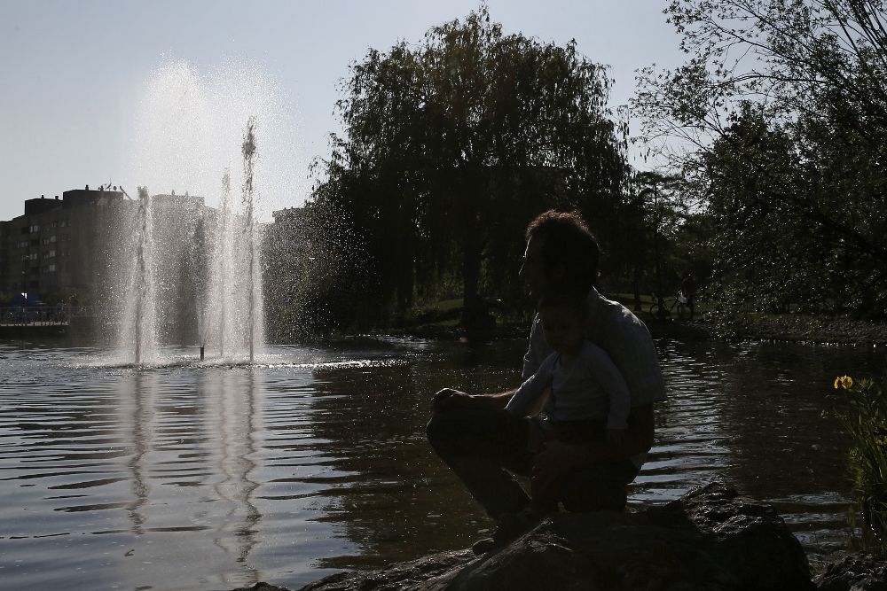 Un hombre disfruta de una tarde soleada en el parque Yamaguchi de Pamplona.