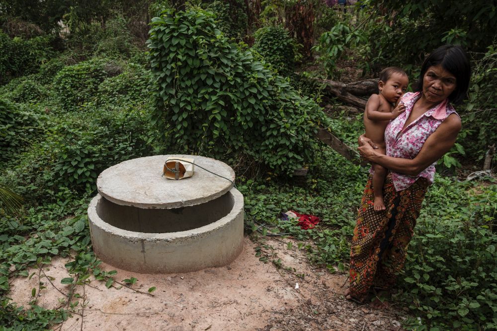 Una mujer sostiene a un bebe junto a un pozo seco a causa de una de las peores sequías que ha sufrido Camboya en décadas.