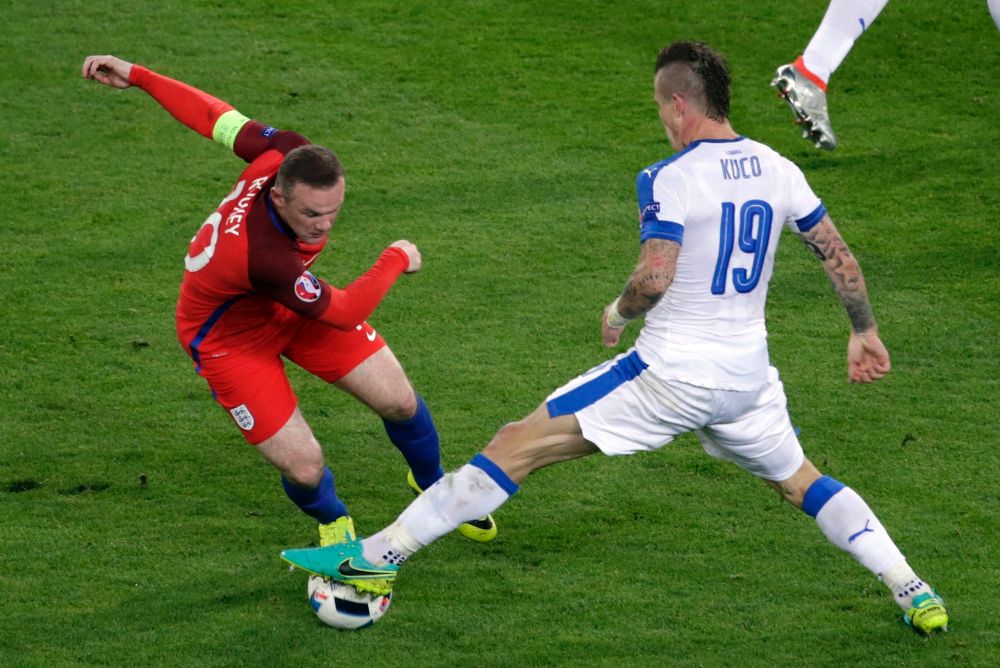 Wayne Rooney (i) en acción durante el partido contra Eslovaquia. Frente a él, Juraj Kucka.