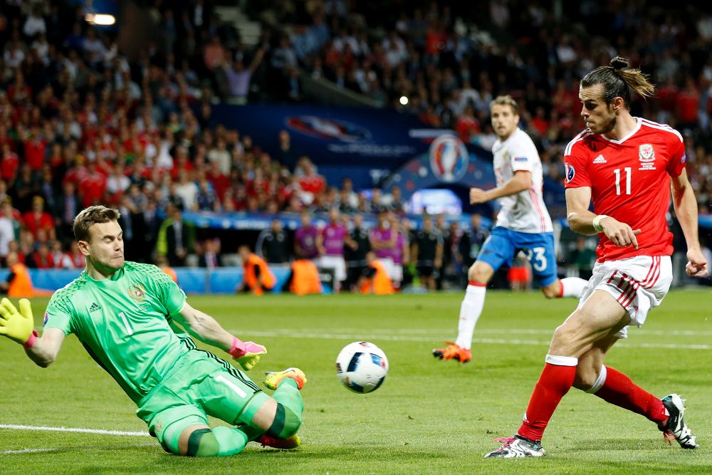 El portero ruso Igor Akinfeev trata de despejar un remate del galés Bale.