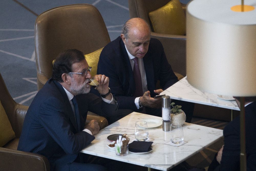 Mariano Rajoy, acompañado por el ministro del Interior en funciones, Jorge Fernandez Díaz, poco antes de su intervención en un foro organizado en Barcelona.