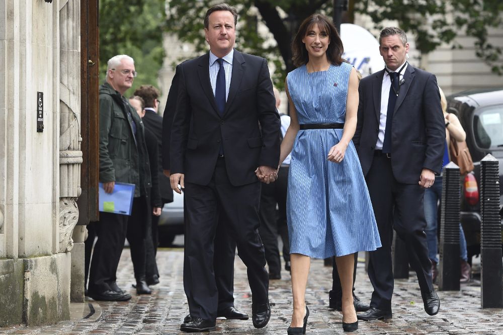 El primer ministro británico, David Cameron (c-i), y su esposa Samantha llegan a un colegio electoral cercano a su residencia oficial en el número 10 de Downing Street para votar.