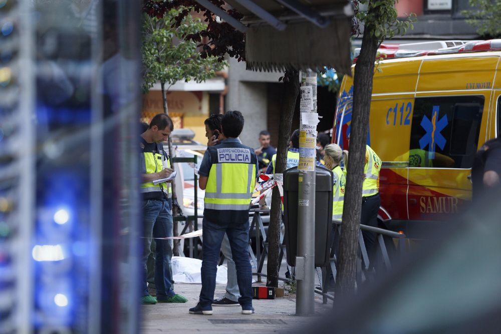 Miembros de los servicios de emergencia y de la Policía ante el número 40 de la calle de Marcelo Usera, de Madrid, tras descubrirse los asesinatos.