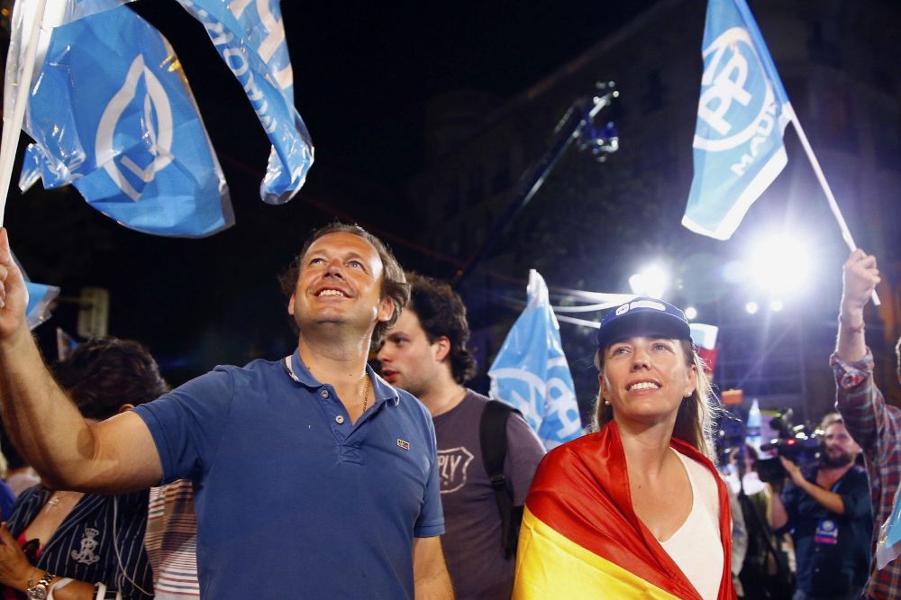 Simpatizantes del Partido Popular junto a la sede del partido en la madrileña calle Génova, tras conocer los resultados electorales.
