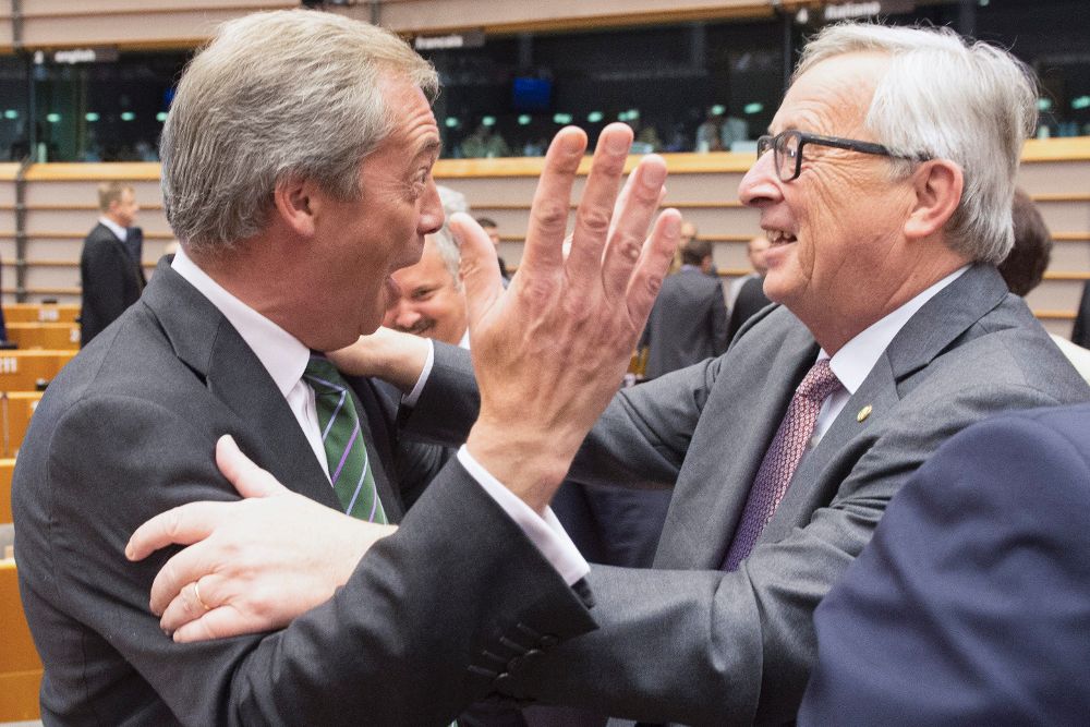 Jean-Claude Juncker (d) saluda al líder del Partido de la Independencia de Reino Unido (UKIP), Nigel Farage, al inicio de una sesión plenaria extraordinaria del Parlamento Europeo.