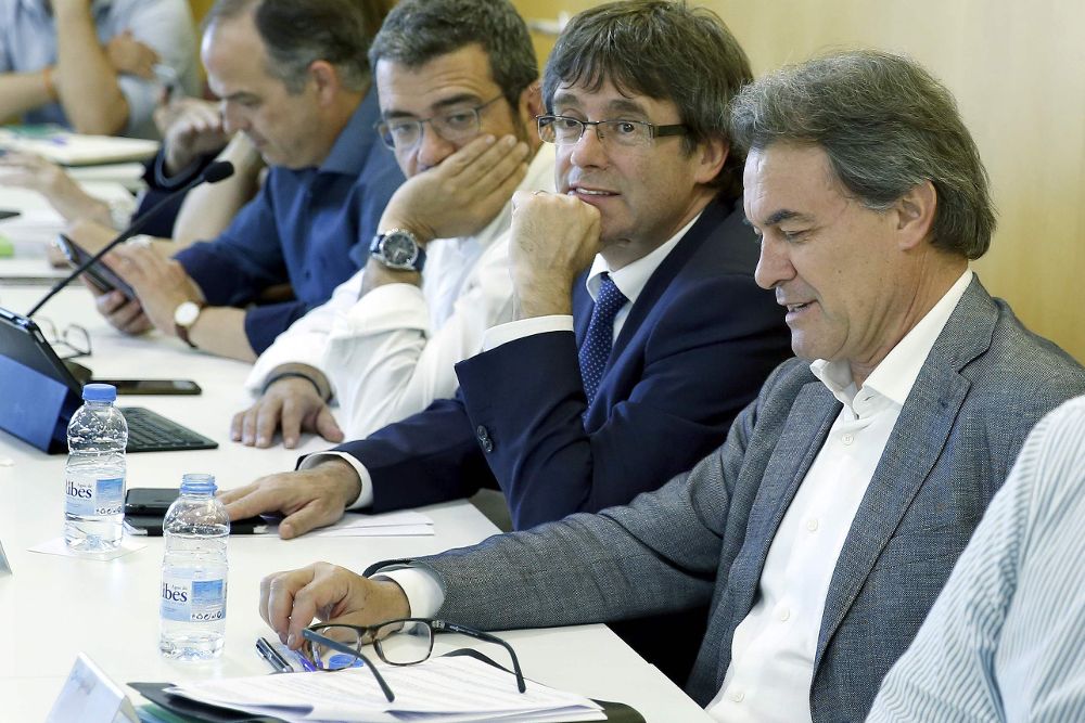 El presidente de CDC, Artur Mas (d), junto al president de la Generalitat, Carles Puigemont (c) durante una reunión del comité ejeutivo de la formación para valorar los resultados de las elecciones generales.