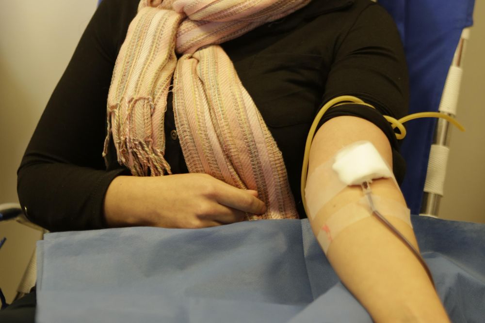 Una mujer dona sangre.