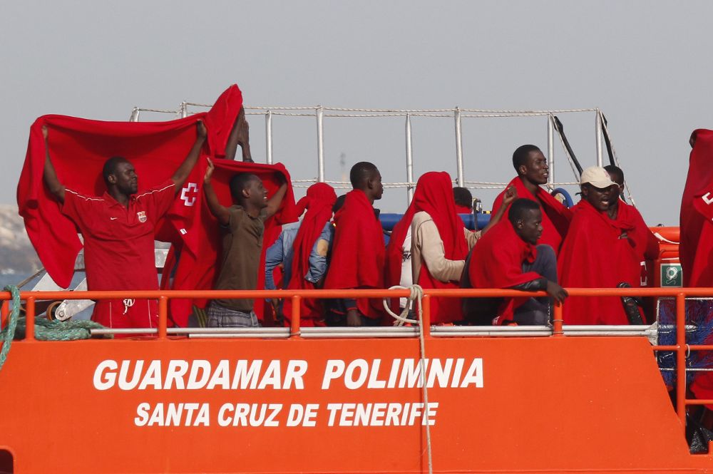 Varios inmigrantes estallan de júbilo al llegar al puerto de Almería.