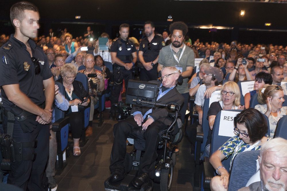 El físico británico Stephen Hawking custodiado por tres agentes de la Policía nacional durante su asistencia al Festival Starmus el pasado miércoles, tras recibir amenazas de muerte por parte de una mujer estadounidense que ha sido detenida en Arona (Tenerife) por supuestos delitos de acoso y amenazas al científico.