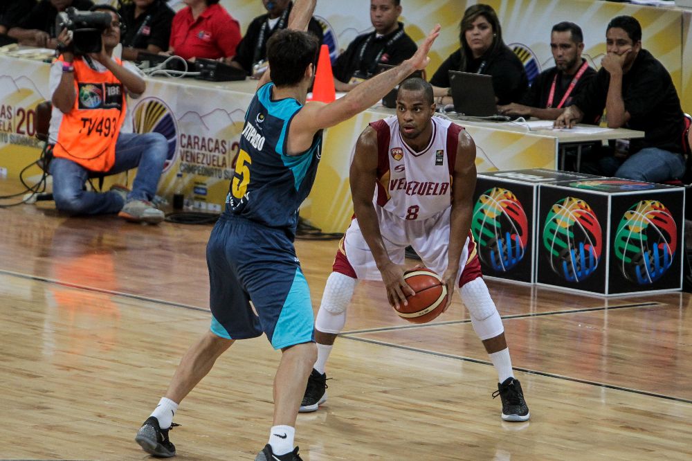 David Cubillán (d), de Venezuela, defiende un balón frente a Bruno Fitipaldo, de Uruguay, durante la semifinal del Campeonato Suramericano de Baloncesto de la FIBA en Caracas.