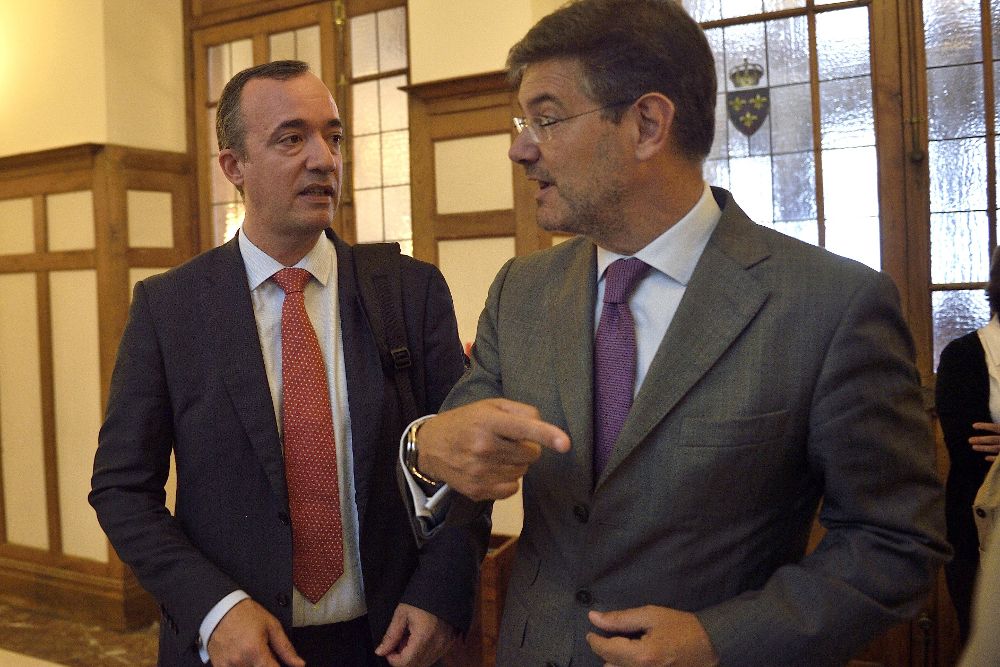 El ministro de Justicia en funciones, Rafael Catalá (d), conversa con el secretario de Estado de Seguridad, Francisco Martínez, hoy, en la UIMP.