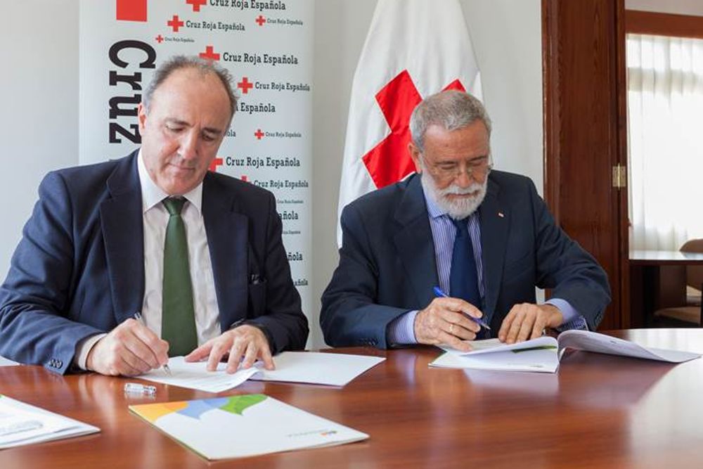 Los representantes de Iberdrola (iz) y Cruz Roja firman el acuerdo.