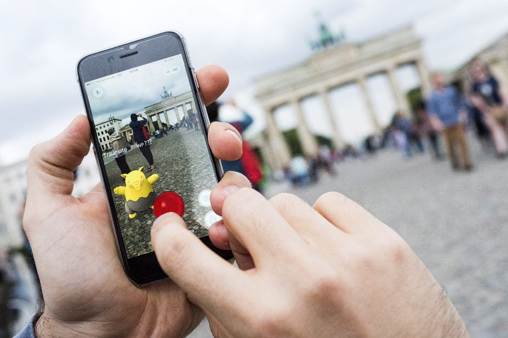 Un jugador intenta atrapar al pokemon "Drowzee" mientras juega a una partida del videojuego "Pokémon Go" gracias a una "app" instalada en su teléfono de última generación, en Berlín, Alemania.