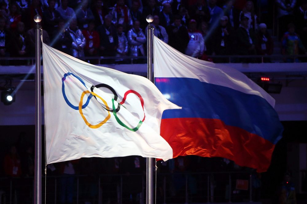 La bandera olímpica y la de Rusia ondeando durante la ceremonia de clausura de los Juegos Olímpicos de Invierno 2014, en Sochi.