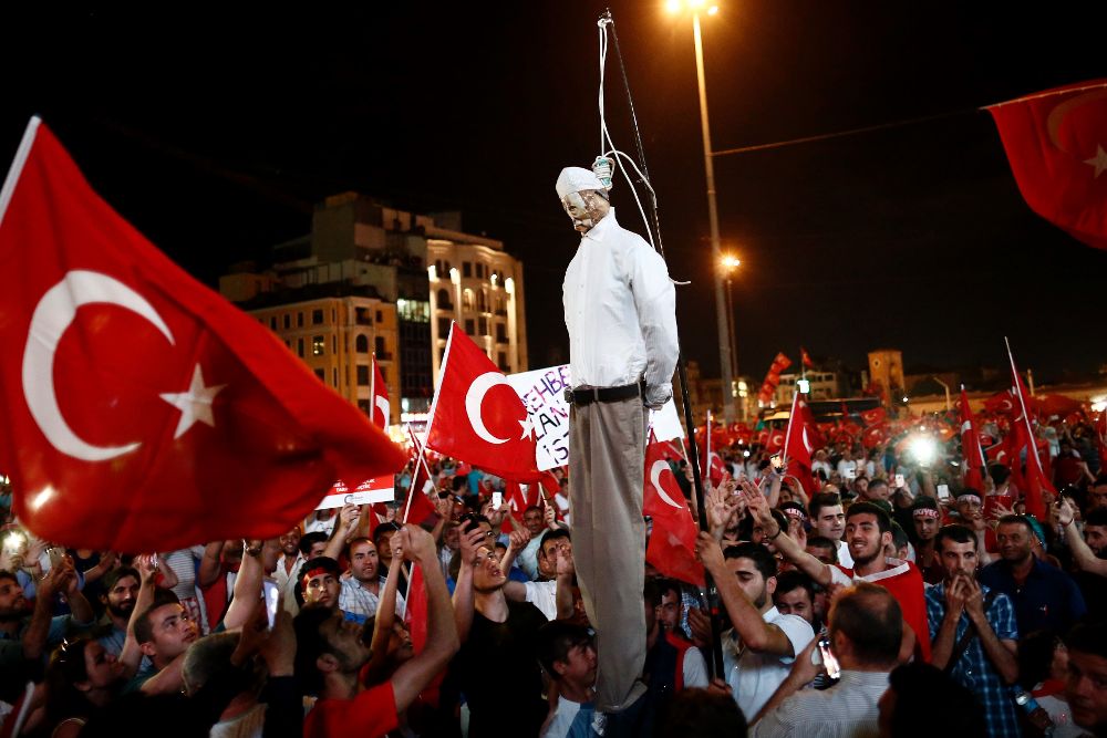 Manifestantes cuelgan una imagen del clérigo turco musulmán Fethullah Gulen, fundador del movimiento Gulen, durante una protesta el lunes 18 de julio de 2016, en la Plaza Taskim en Estambul (Turquía).